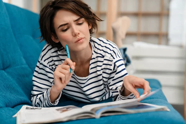 Brooding Mooie Student Meisje Doet Huiswerk Terwijl Liggend Bank Thuis — Stockfoto