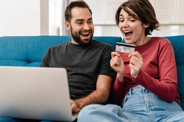 Aufgeregtes Junges Paar Benutzt Laptop Und Kreditkarte Während Hause Auf — Stockfoto