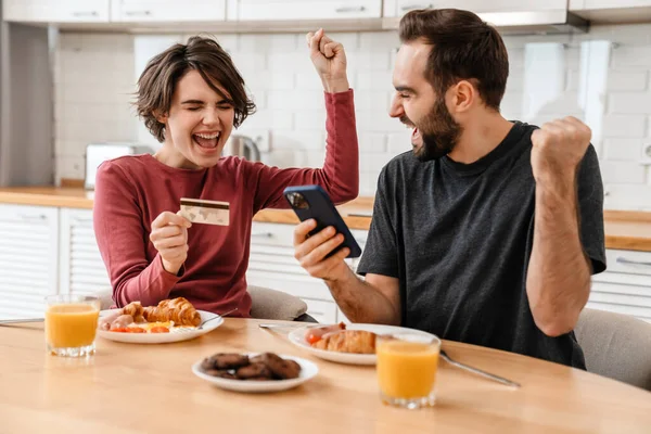 Emocionada Pareja Haciendo Gesto Ganador Utilizando Teléfono Celular Tarjeta Crédito — Foto de Stock