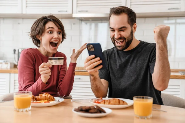 Emocionada Pareja Haciendo Gesto Ganador Utilizando Teléfono Celular Tarjeta Crédito — Foto de Stock