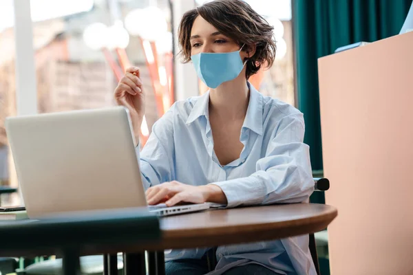 Menina Caucasiana Agradável Máscara Protetora Trabalhando Com Laptop Café Dentro — Fotografia de Stock