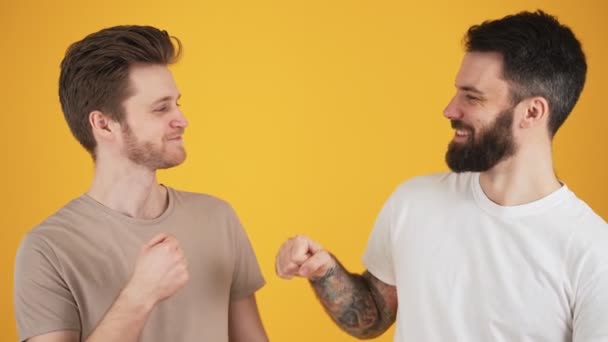 Двоє Щасливих Друзів Хлопці Стоять Над Жовтою Стіною Студії — стокове відео