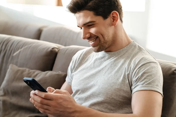 Šťastný Pohledný Mladý Muž Pomocí Mobilního Telefonu Při Relaxaci Licenční — Stock fotografie