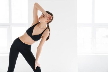 Yorgun genç sporcu kadın içeride çalışırken dinleniyor.