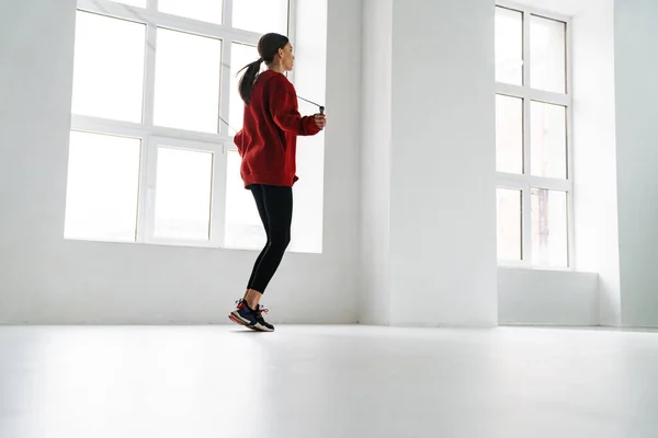 运动的年轻女运动员在室内用跳绳锻炼 — 图库照片