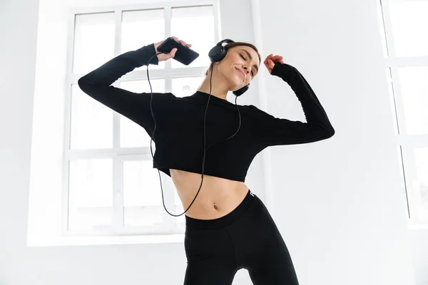 Mujer Feliz Bailando Mientras Escucha Música Con Auriculares Teléfonos Inteligentes —  Fotos de Stock