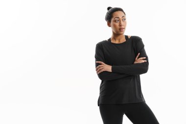 Ciddi Afrikalı Amerikalı kadın beyaz arka planda yalnız poz veriyor ve yan bakıyor.