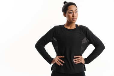 Ciddi Afrikalı Amerikalı kadın beyaz arka planda yalnız poz veriyor ve yan bakıyor.