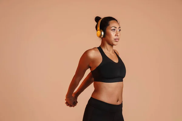 Mujer Afroamericana Enfocada Auriculares Haciendo Ejercicio Mientras Hace Ejercicio Aislado —  Fotos de Stock