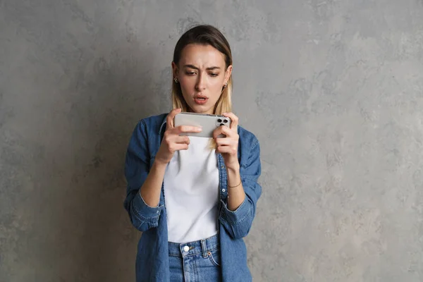 Σύγχυση Νεαρή Γυναίκα Κοιτάζοντας Κινητό Τηλέφωνο Ενώ Στέκεται Απομονωμένη Πάνω — Φωτογραφία Αρχείου