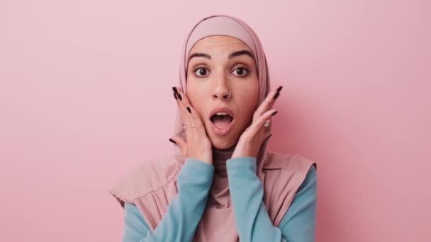 Yllättynyt Arabialainen Nainen Katsoo Kameraan Joka Seisoo Eristyksissä Studion Vaaleanpunaisen — kuvapankkivideo