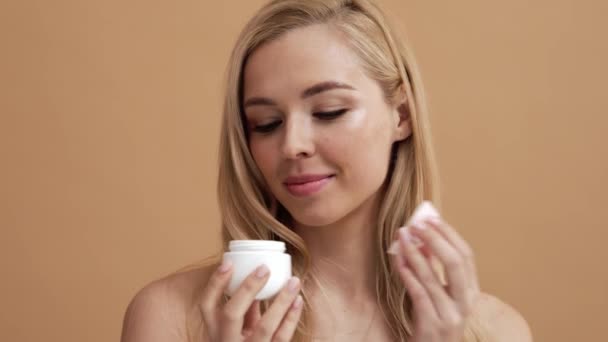 Una Mujer Rubia Positiva Está Sosteniendo Una Crema Oliendo Aroma — Vídeos de Stock