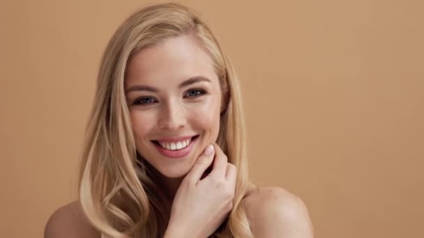 Szczęśliwa Blondynka Pozuje Kamery Stojącej Beżowej Ścianie Studio — Wideo stockowe
