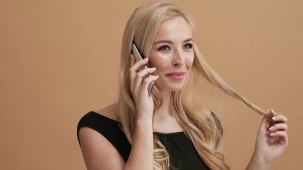 Leende Blond Kvinna Talar Smartphone Stående Isolerad Över Beige Vägg — Stockvideo