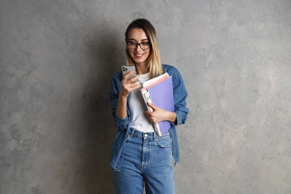 Feliz Joven Estudiante Casual Atractiva Sosteniendo Cuadernos Mientras Está Pie —  Fotos de Stock