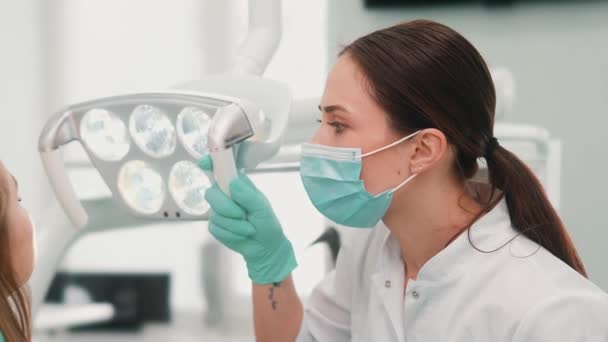 Uma Mulher Dentista Usando Uma Máscara Protetora Está Consertando Dentes — Vídeo de Stock