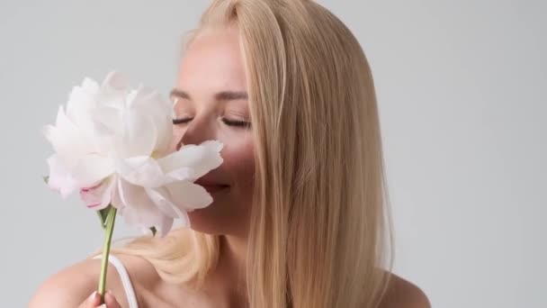 Vacker Ung Blond Kvinna Sniffar Doften Blomma Stående Isolerad Över — Stockvideo