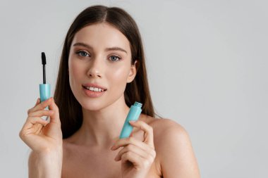 Beyaz arka planda maskarayla poz verirken kameraya bakan güzel üstsüz kız.