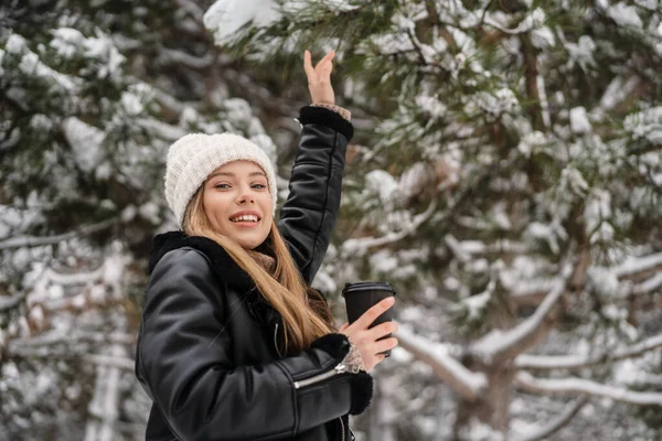在冬天的森林里散步的时候 快乐美丽的姑娘一边喝着咖啡一边走 — 图库照片