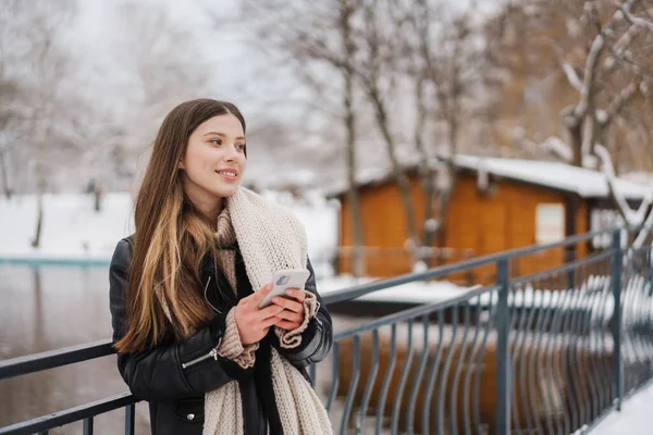 Menina Bonita Feliz Usando Celular Sorrindo Enquanto Caminha Parque Inverno — Fotografia de Stock