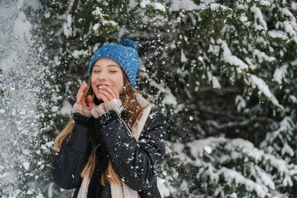 在冬天的森林里散步的时候 戴着针织帽子和雪开玩笑的美丽的快乐姑娘 — 图库照片