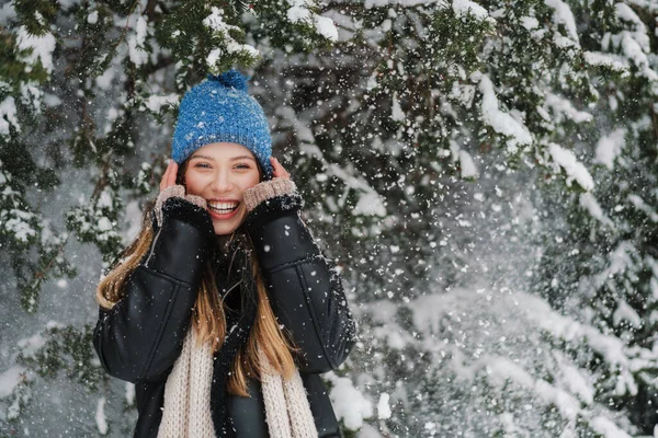 在冬天的森林里散步的时候 戴着针织帽子和雪开玩笑的美丽的快乐姑娘 — 图库照片