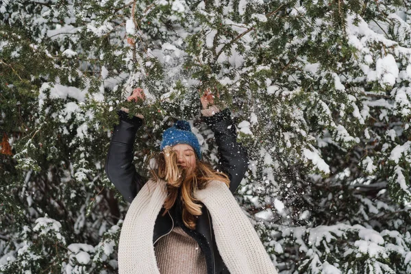在冬天的森林里散步的时候 戴着针织帽子和雪开玩笑的美丽的快乐姑娘 — 图库照片
