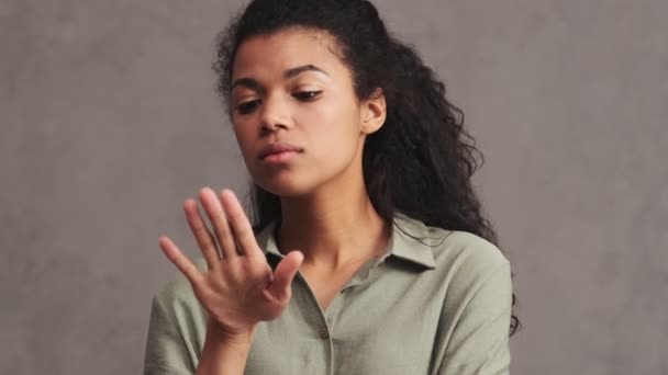 Een Serieuze Afro Amerikaanse Vrouw Kijkt Naar Haar Nagels Geïsoleerd — Stockvideo