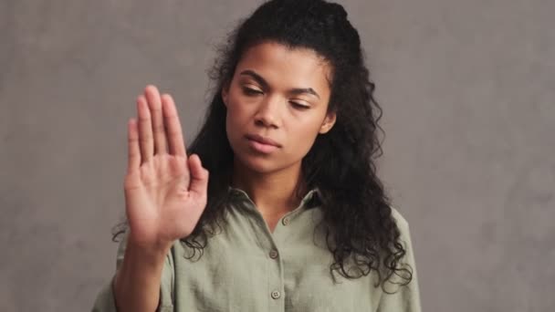 Poważna Afroamerykanka Pokazuje Gest Zatrzymania Wyizolowany Nad Szarą Ścianą Studio — Wideo stockowe