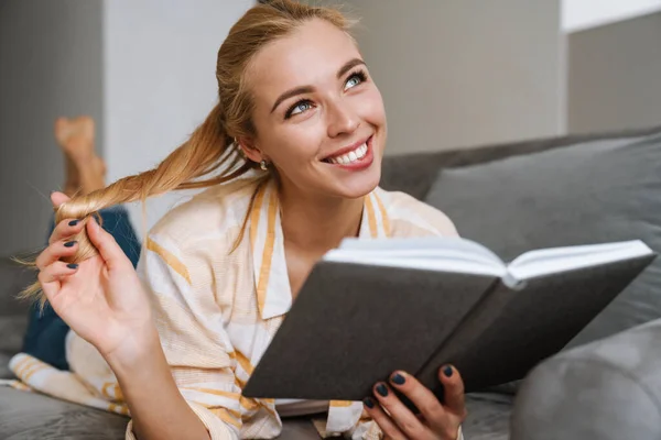 Mujer Feliz Sonriendo Leyendo Libro Mientras Está Acostado Sofá Casa —  Fotos de Stock