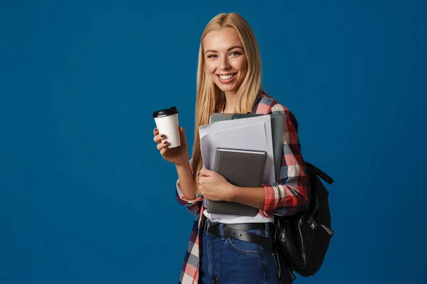 ブロンド幸せな女性笑顔ながらポーズでコーヒーとノート隔離された上の青の背景 — ストック写真