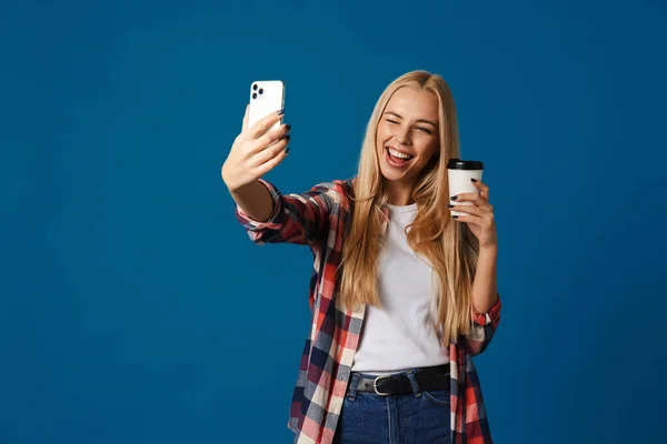 Chica Alegre Tomando Selfie Teléfono Inteligente Mientras Bebe Café Aislado — Foto de Stock