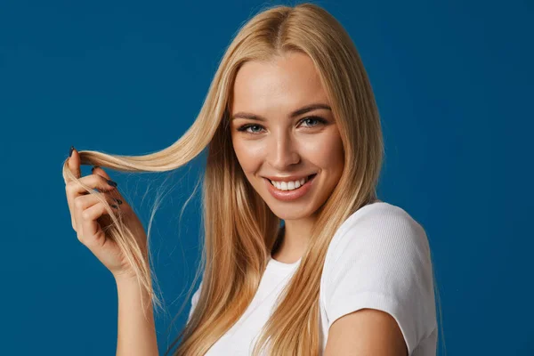 Blonde Young Happy Woman Smiling Playing Her Hair Isolated Blue — Stock Photo, Image