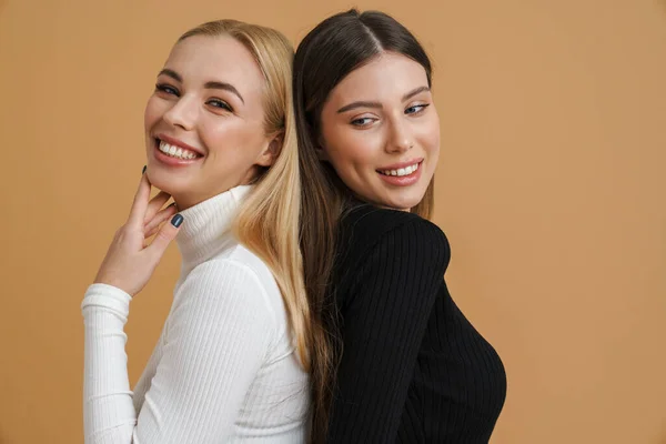 Hermosas Mujeres Sonrientes Posando Espalda Con Espalda Cámara Fondo Beige —  Fotos de Stock