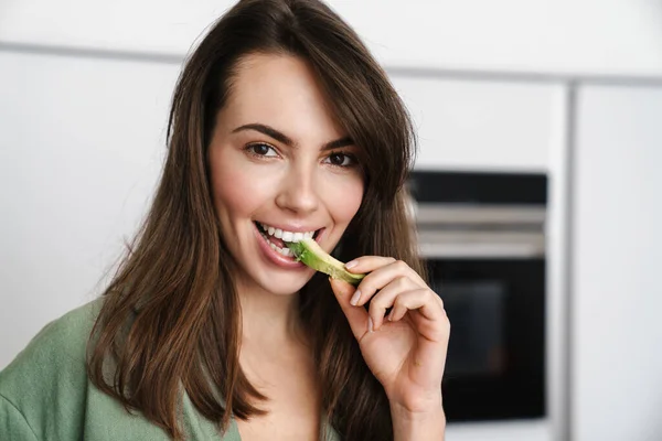 Joyful Brunette Woman Smiling While Eating Avocado Home Kitchen — Stock Photo, Image