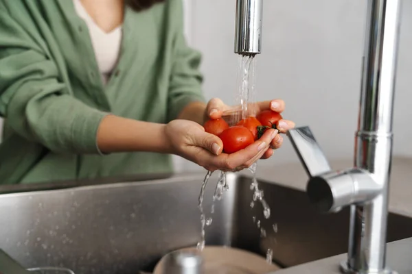 白人の若い女性洗濯トマトにホームキッチン — ストック写真