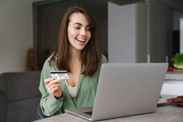 Mujer Agradable Alegre Usando Tarjeta Crédito Mientras Trabaja Con Ordenador —  Fotos de Stock