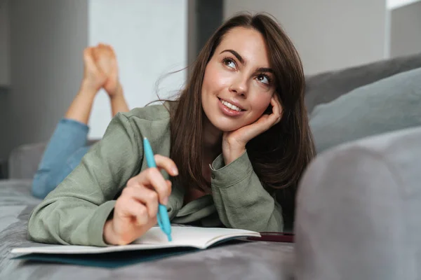 Leende Kvinna Som Ligger Soffan Och Skriver Dagbok — Stockfoto