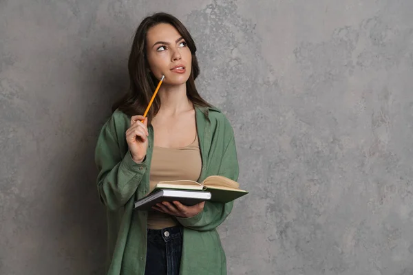 Thinking Brunette Nice Girl Writing Notes Exercise Book Isolated Grey — Stock Photo, Image