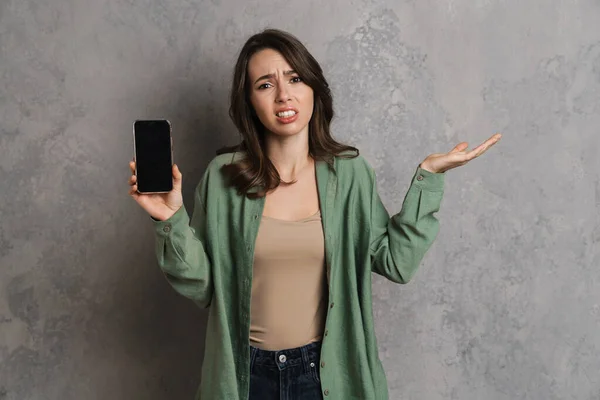 Chica Confusa Sosteniendo Espacio Copia Mientras Muestra Teléfono Celular Aislado — Foto de Stock