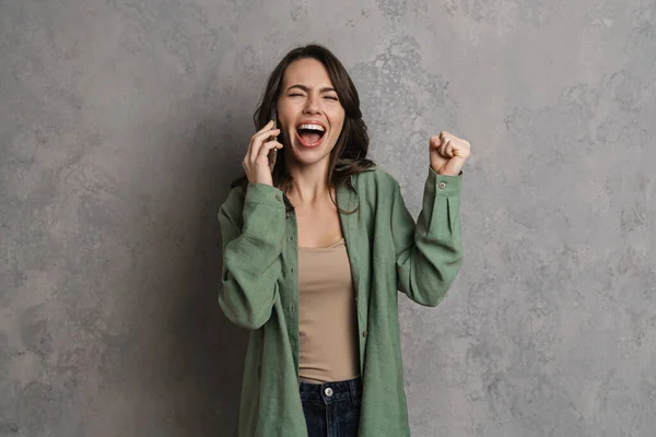 Muchacha Emocionada Haciendo Gesto Ganador Mientras Habla Teléfono Celular Aislado — Foto de Stock