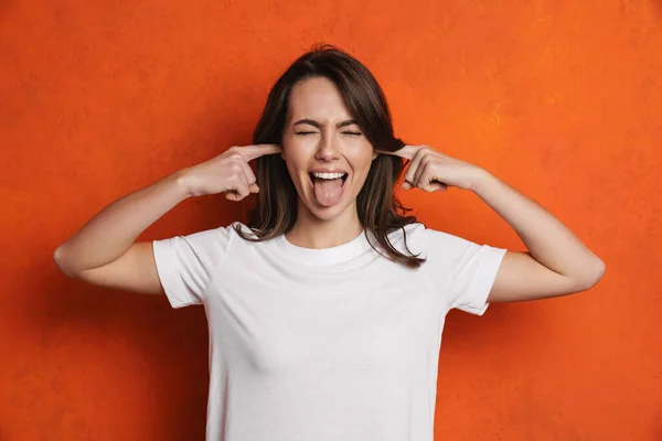 Vrolijk Meisje Tonen Haar Tong Terwijl Pluggen Haar Oren Geïsoleerd — Stockfoto