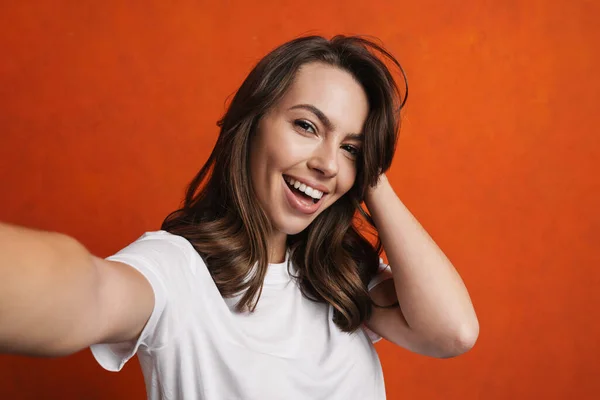 Šťastná Krásná Dívka Úsměvem Při Focení Selfie Izolované Přes Oranžovou — Stock fotografie
