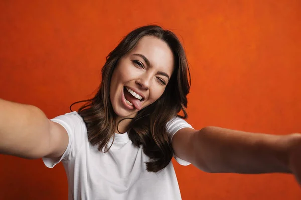 Zabawna Piękna Dziewczyna Pokazuje Swój Język Podczas Robienia Selfie Pomarańczowej — Zdjęcie stockowe