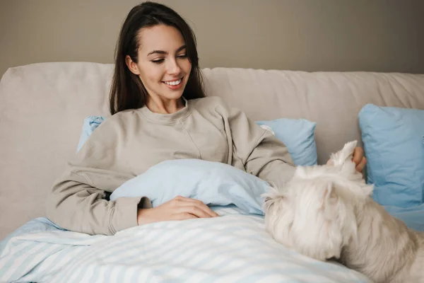 Feliz Mujer Blanca Acariciando Perro Mientras Está Sentada Cama Casa — Foto de Stock