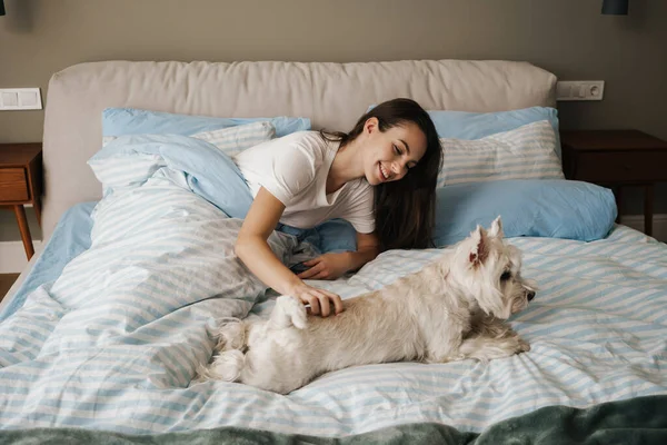 Mutlu Beyaz Kadın Evde Yatarken Köpeğini Okşuyor — Stok fotoğraf