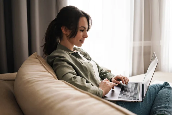 Mujer Joven Sonriente Con Computadora Portátil Casa Sentada Sofá — Foto de Stock