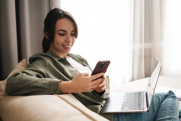 Mujer Joven Sonriente Con Computadora Portátil Casa Sentada Sofá Mirando — Foto de Stock