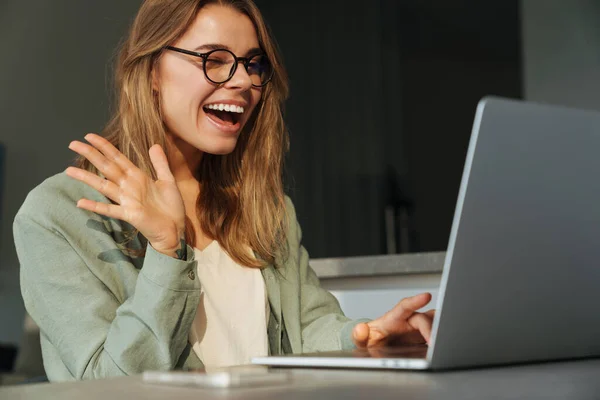 Feliz Mulher Agradável Acenando Mão Piscando Enquanto Trabalhava Com Laptop — Fotografia de Stock