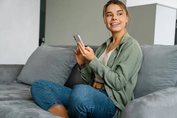 Glückliche Schöne Frau Mit Handy Während Sie Hause Auf Dem — Stockfoto